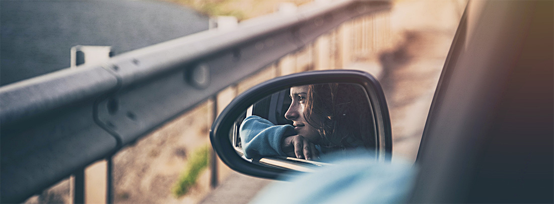 Frau spiegelt sich im Außenspiegel